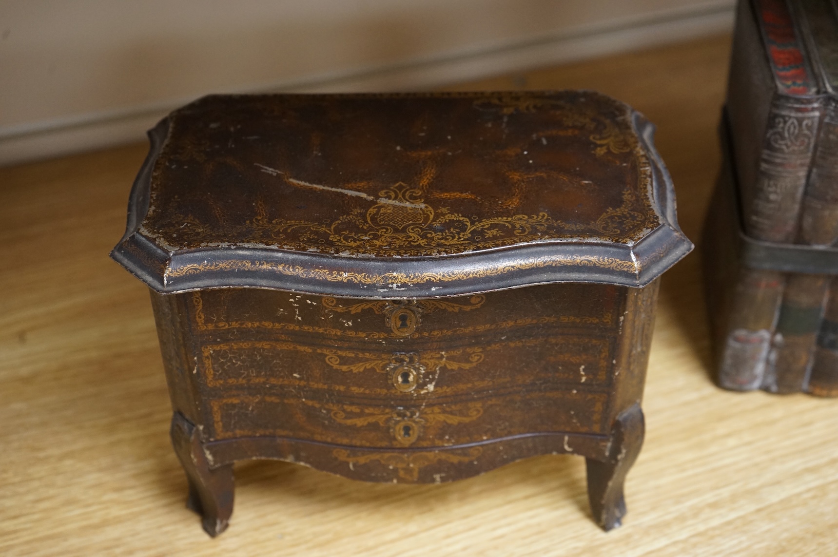 A Huntley and Palmer biscuit tin, modelled as a set of books and and two Mcvitie and Price tins modelled as French chests, tallest 16cm